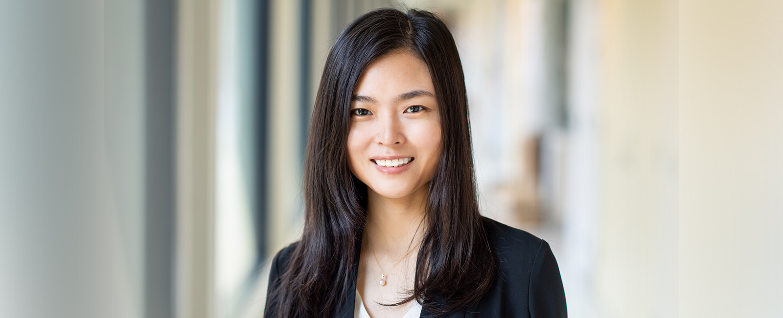 Professor Xiao Wang smiles in the hallway of Building 18.