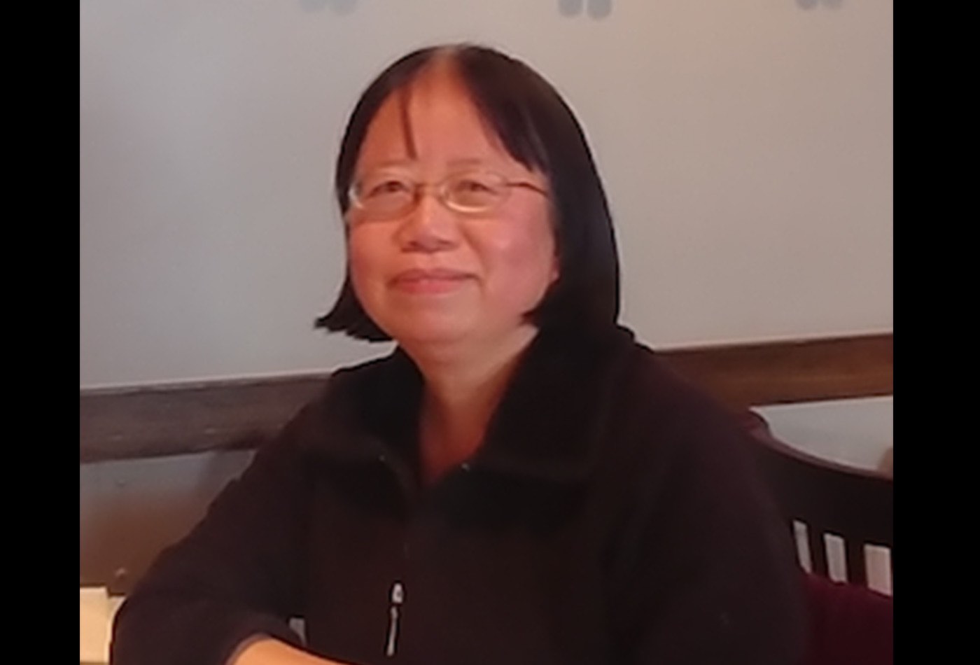 Li Miao smiles in front of a whiteboard.