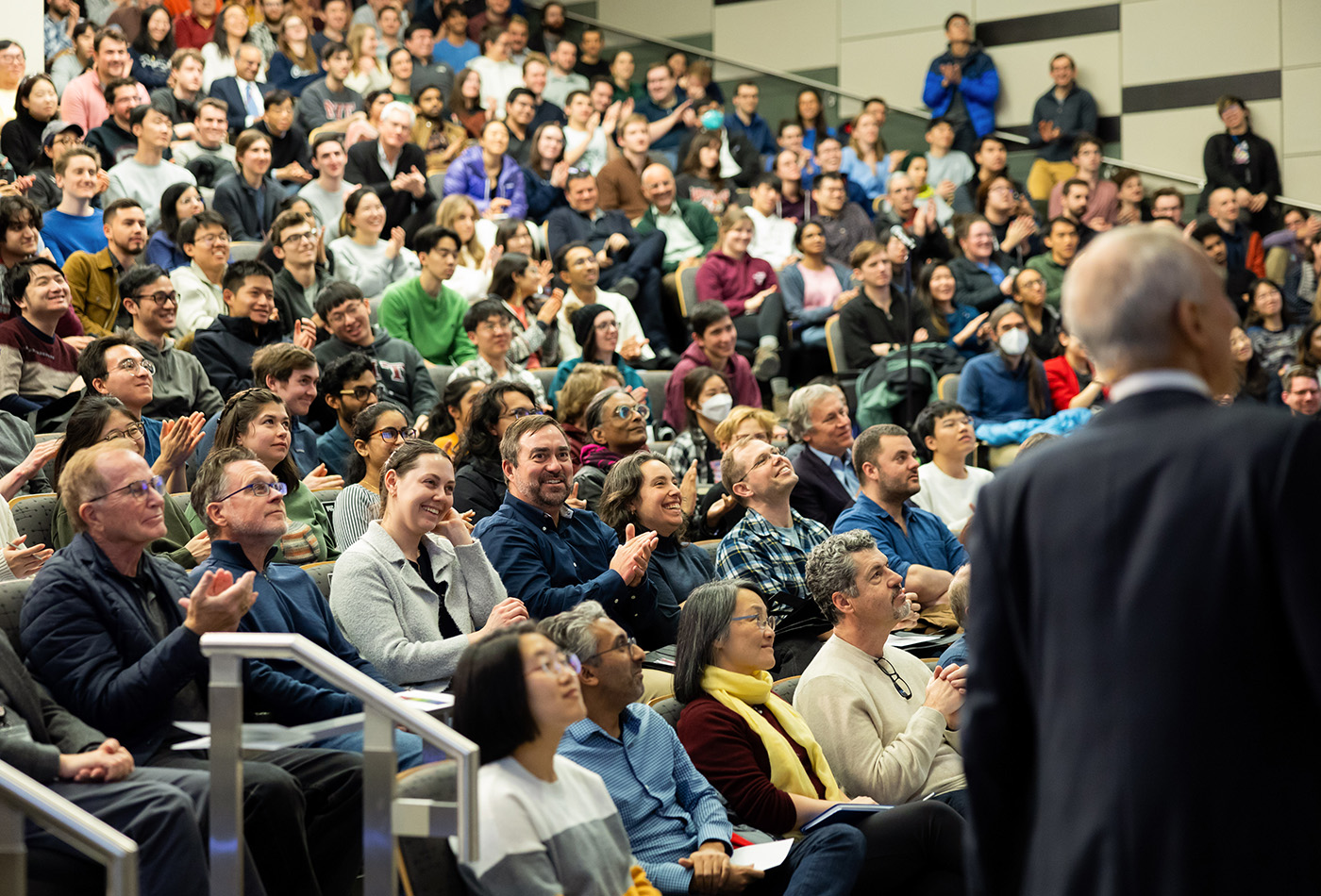 A photo of a packed audience from the point of view of the speaker.